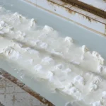 Khối cao su thiên nhiên đông tụ trong bể nước tại công đoạn sơ chế cao su
